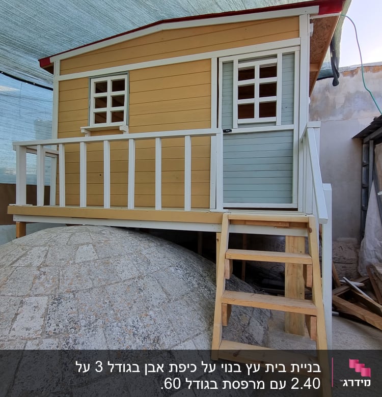 בית עץ קטן עם מדרגות עץ בחצר